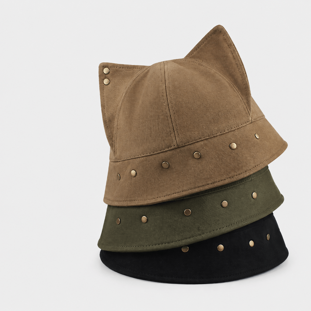 Brown, olive green and black cat ear bucket hats stacked together with metal stud details.