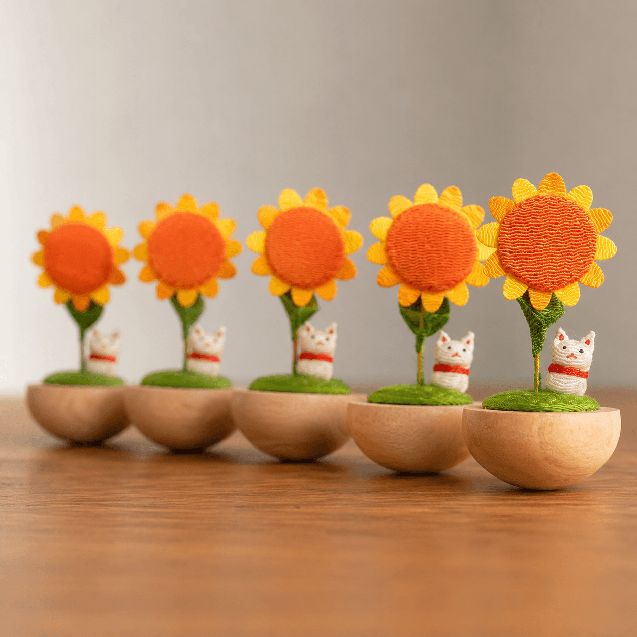 Handmade Japanese Sunflower Cat Ornament displayed in warm natural light on a wooden tabletop.