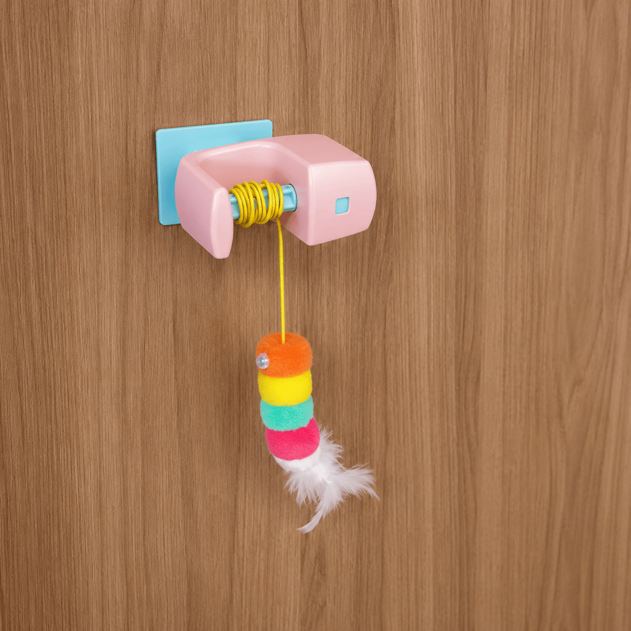 Close-up of Vertical Hunt automatic hanging cat toy featuring feather teaser attachment and bell for interactive cat play